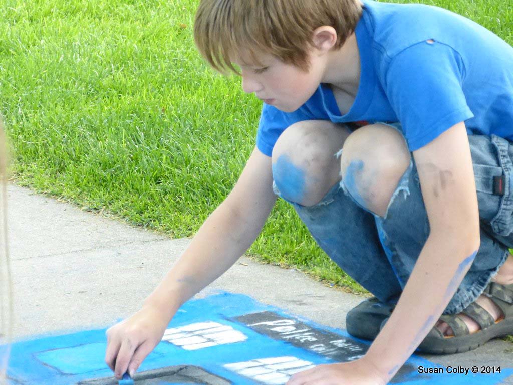 Great concentration and full body participation in the sidewalk art competition