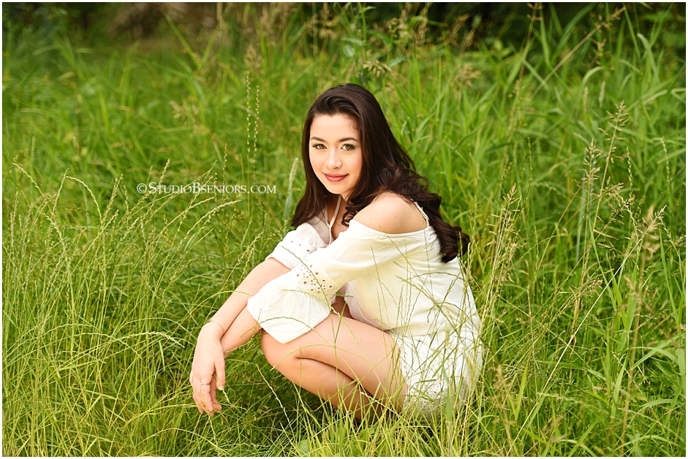 Studio B Portraits Senior Pictures with girl in lace romper sitting in the grass