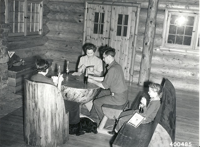 A_family_group_playing_cards_in_the_Community_Building_on_a_rainy_day_at_the_South_Kawishiwi_River_camp_and_Picnic_Ground,_8_1_1940_(5188124888)
