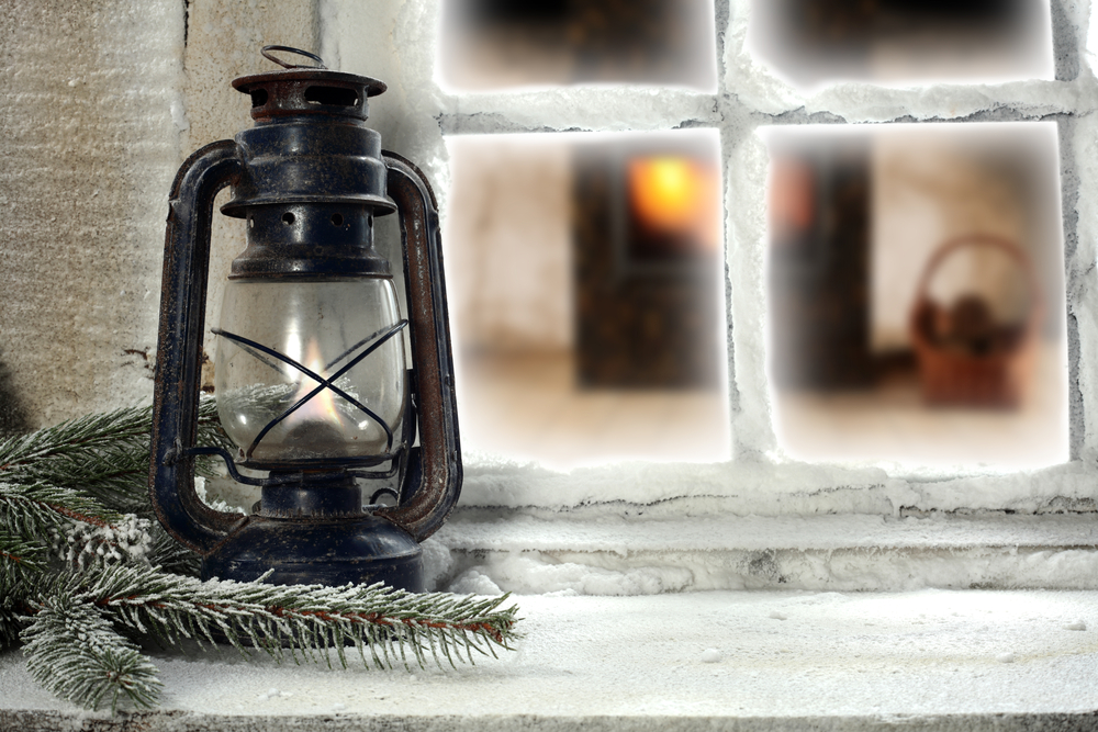 Home window in winter time decorated with a lantern and pine needles