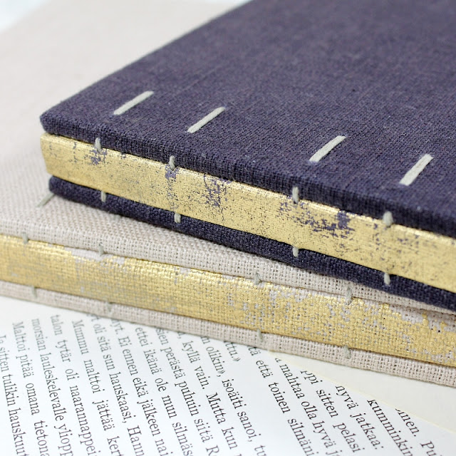 Coptic bound books with distressed gold linen spines by Kaija Rantakari / paperiaarre.com