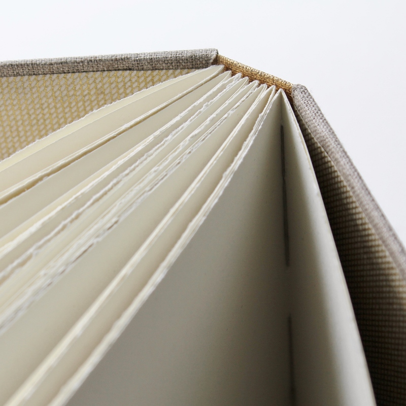 handmade long stitch photo album with distressed gold spine and natural linen covers by Kaija Rantakari / www.paperiaarre.com