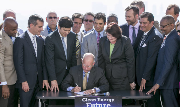 California Gov. Jerry Brown signs bill to combat climate change by increasing the state's renewable electricity use to 50 percent and doubling energy efficiency in existing buildings by 2030 at a ceremony Wednesday, Oct. 7, 2015. (AP Photo/Damian Dovarganes)