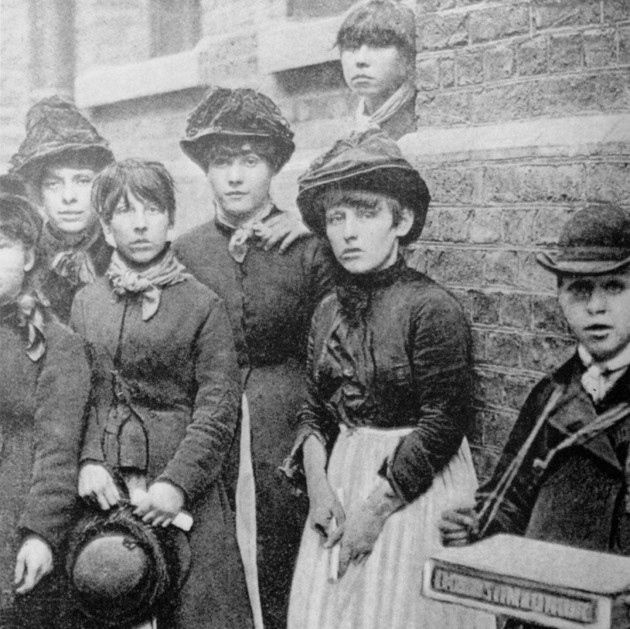 A group of matchwomen leaning against a wall