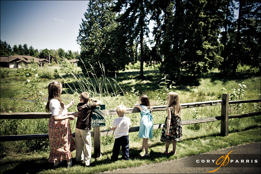 kids looking over a fence by seattle wedding photojournalists cory parris