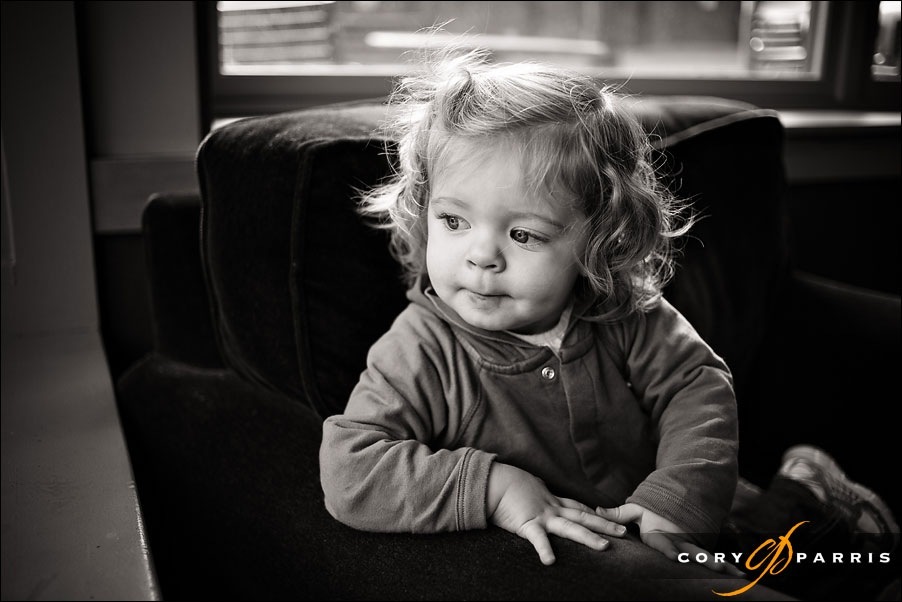 b&w portrait of a little girl in a chair looking out a window at Starbucks by seattle portrait photographer