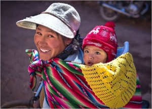 [Fotografía de Omnifoto-J. Alberto Mariñas que muestra a una madre con su bebé a cuestas en la localidad peruana de Pucará]. 