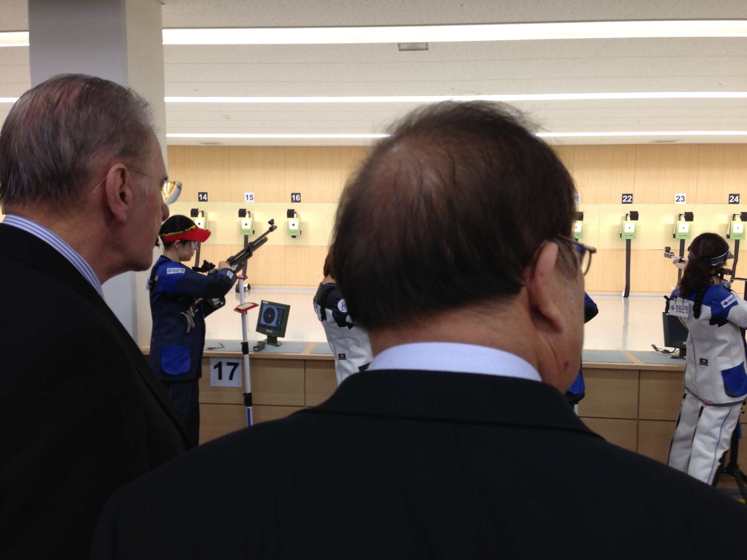 Jacques Rogge, the IOC president, left, watches Korean shooters practice at the Jincheon National Training Center