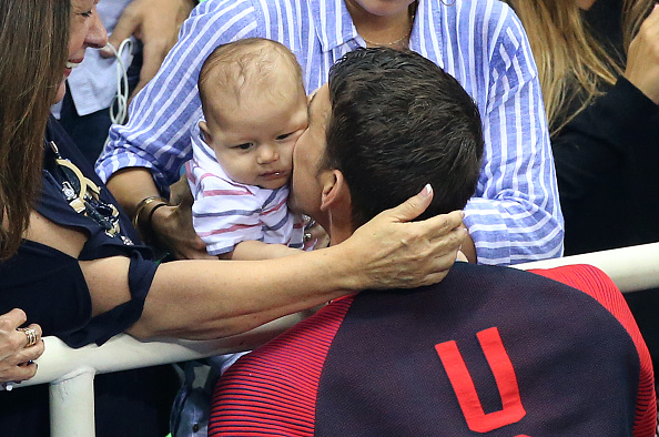 Gold medalist Michael Phelps kisses 3-month- old son Boomer after the 200 fly medal ceremony // Getty Images 