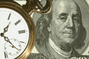 Time and Money concept image. us currency and a pocket watch portray time and money.Business concept.