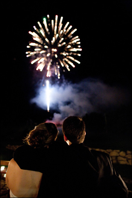 Happy couple watches fireworks light-up the night time sky