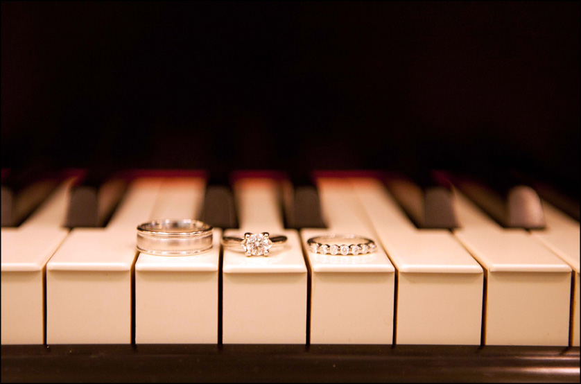 Wedding rings are photographed on the keys of a piano