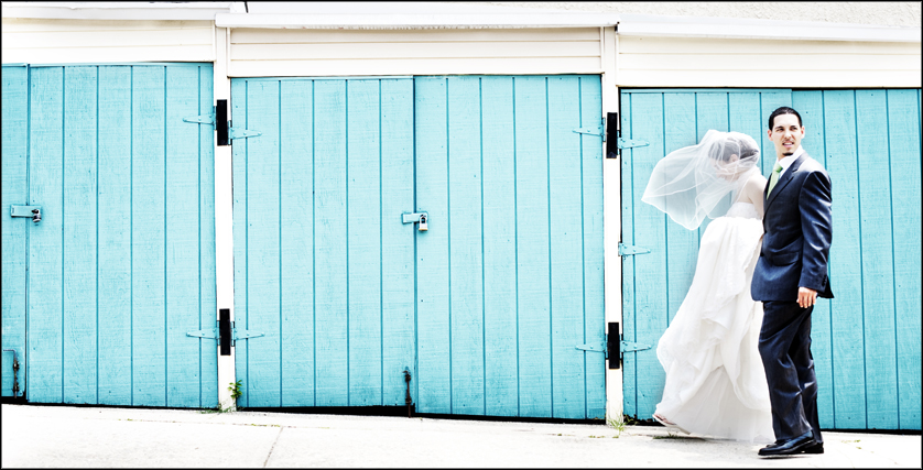 wind blows bride's veil with blue wall
