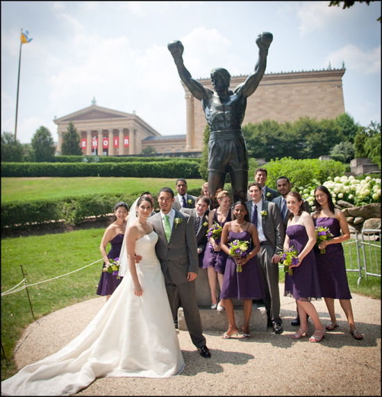 bridal party pose for photos in front of Rocky statue in Philadelphia