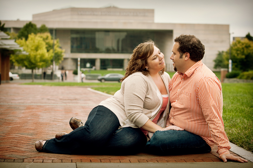 Couple sitting in Old City with National Constitution Center behind them in Philadelphia, PA