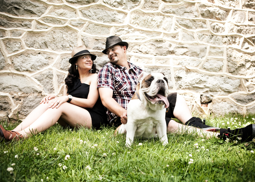 Vintage-style engagement portraits with bulldogs by old stone wall
