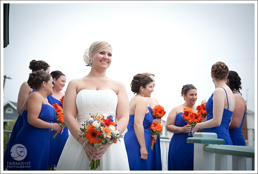 Candid bridesmaids photo blue bridesmaids dresses and orange bouquets