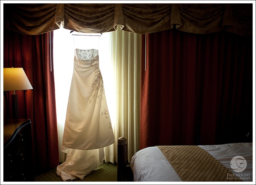 wedding dress in window with red curtains