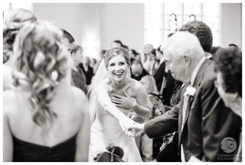 happy bride shakes grandfather's hand during the sign of peace