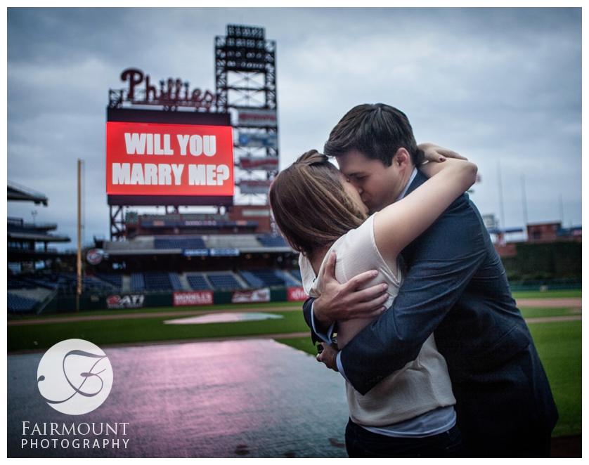 Newly-engaged couple kiss on field at Citizen's Bank Park