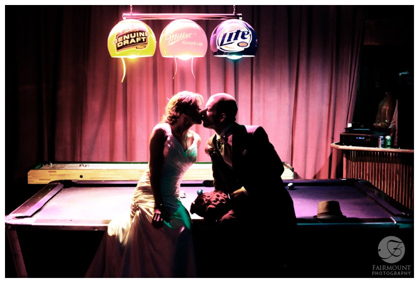 dramatic portrait of bride & groom sitting on a pool table at the Electric Factory