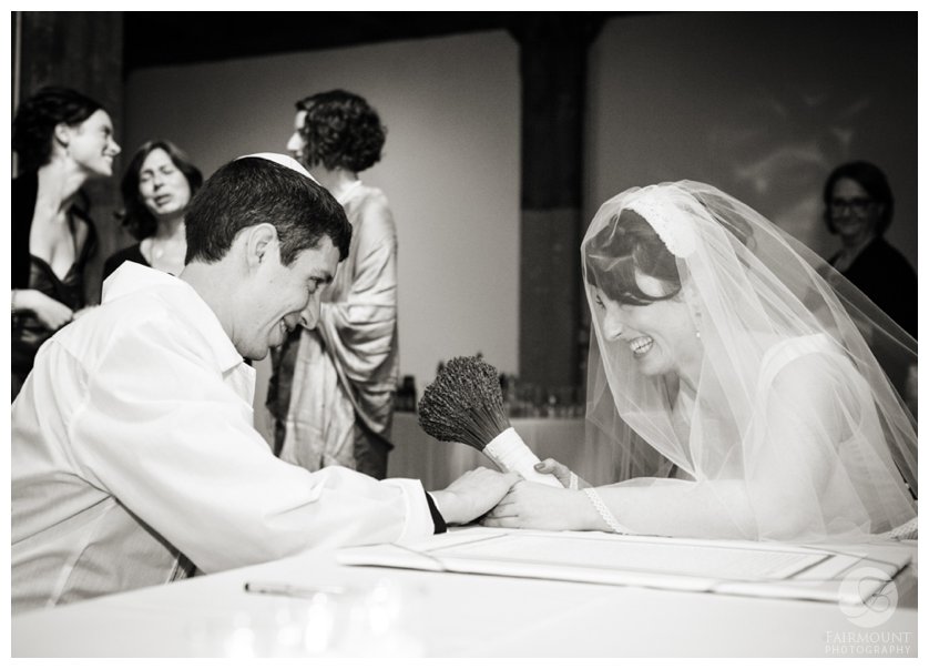 bride & groom smile at each other during the signing of the ketubah marriage contract