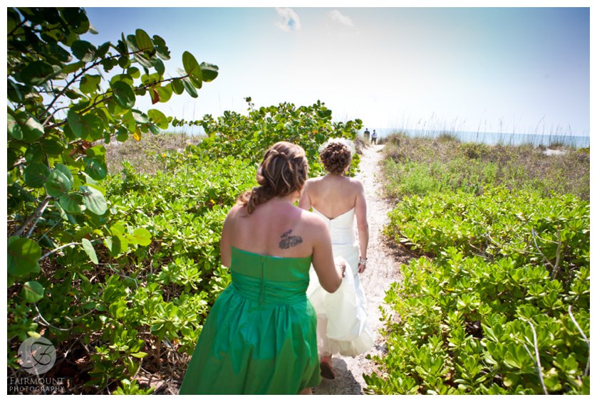 bride and maid of honor follow a path to the beach for first look at Sanibel Island destination wedding