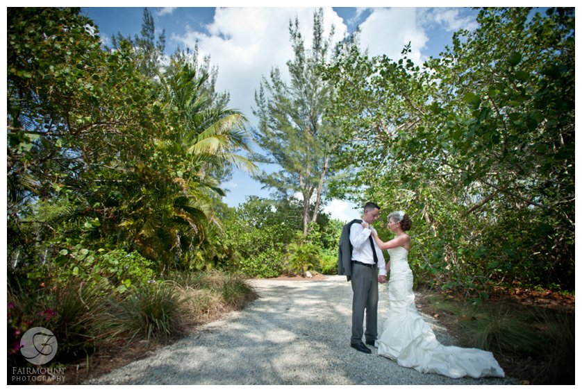 Groom in gray suit and bride in mermaid gown for beach wedding in Sanibel Island, FL