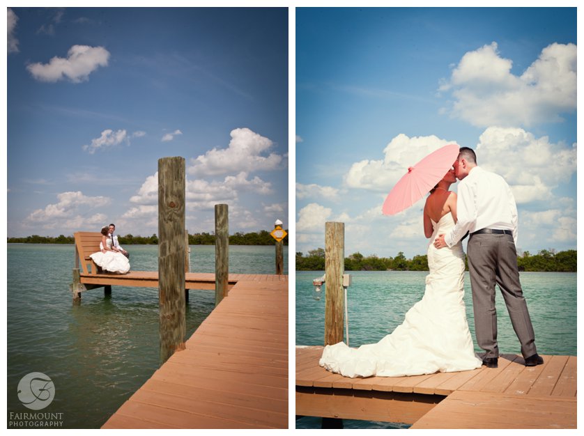 bride and groom kiss under a coral parasol on the dock leading to the bay off Captiva Island