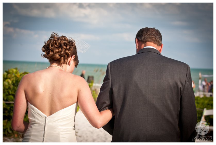 bride and her father walk down beach path to destination wedding in South Florida