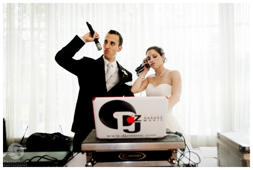 Bride and groom joke with dj equipment