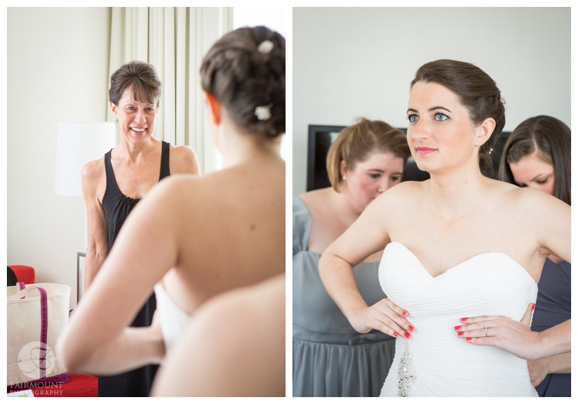mother of the bride watches as bride puts on wedding dress
