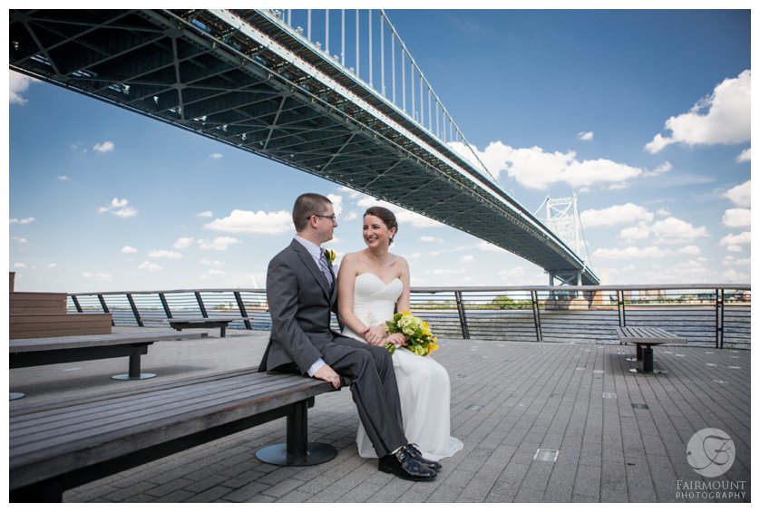 Bride & groom under the Ben Franklin Bridge at Race Street Pier