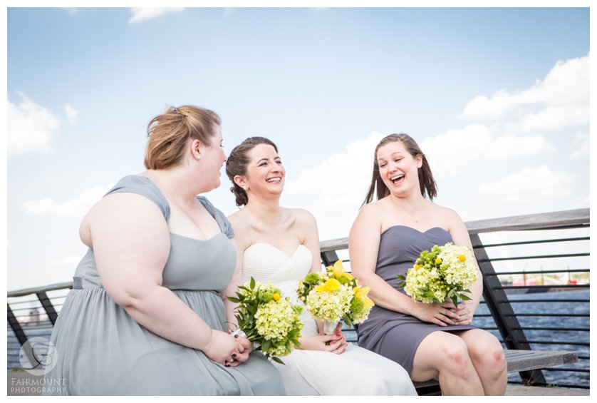 bride and bridesmaid laughing and having fun at Race Street Pier