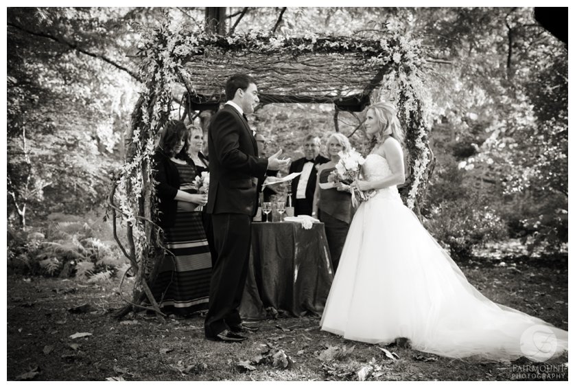 exchanging vows under chuppah made of branches