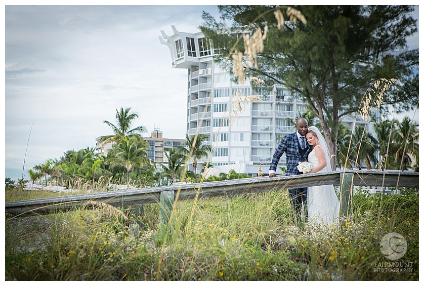 Bride and groom on bridge at beach