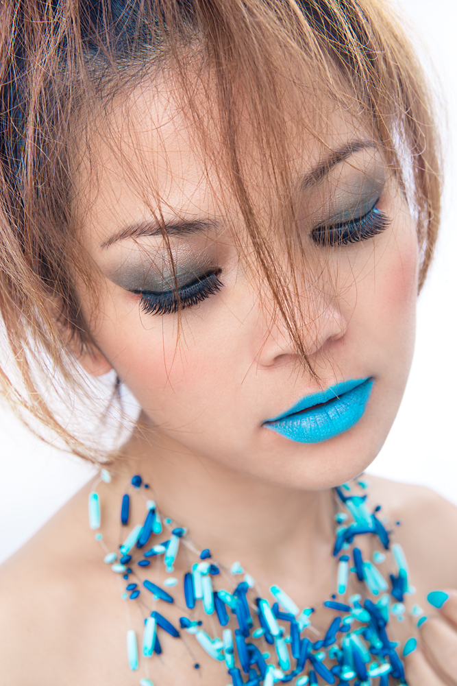 A beauty shot of a woman with blue tone make up