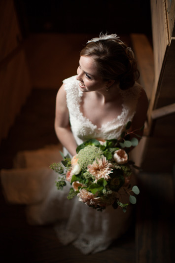 bride with wedding flowers at cottonwood barn