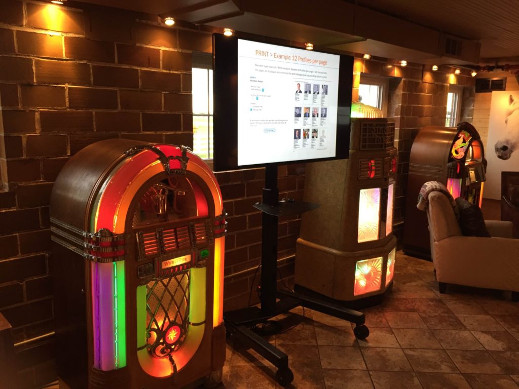 Picture of interior of the Green Acres event center showing multiple jukeboxes and an AV for You monitor on a portable stand.