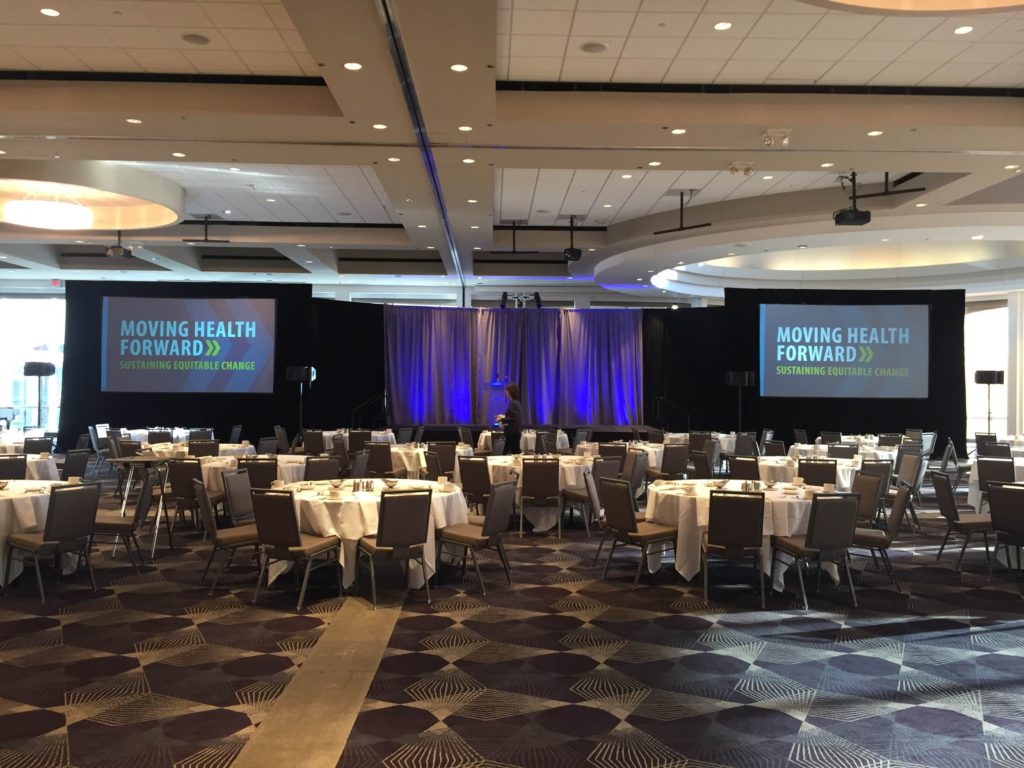 Picture of AV for You Rental Blue Cross Blue Shield Minnesota Luncheon at Intercontinental Hotel set-up featuring a stage and two Dalite Fastfold Screens