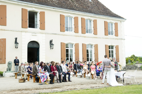 Exterior shot of château and wedding party during wedding ceremony
