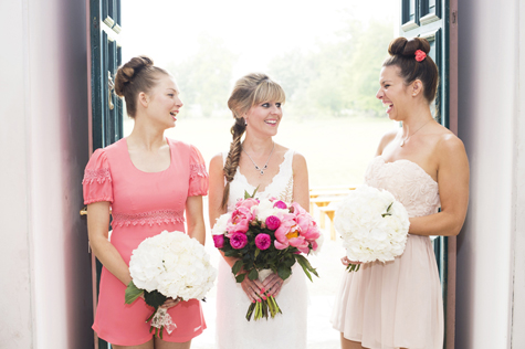 The bride and her two bridesmaids with bouquets laughing