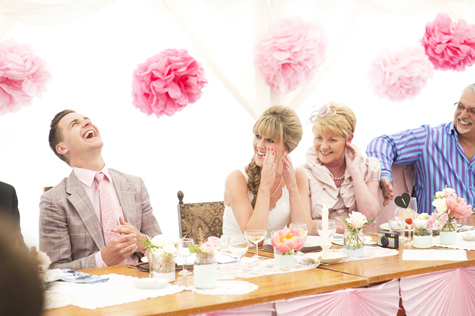 Groom laughing with bride and bride's mother during speech
