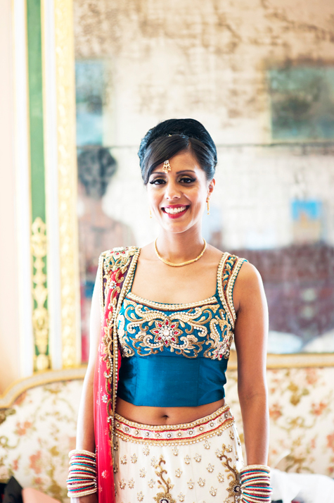 Portrait shot of bride in full wedding outfit smiling radiantly