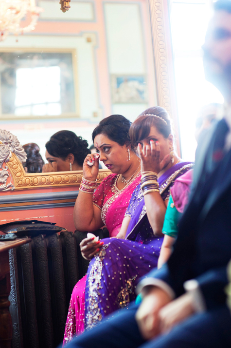 Bride's mother and relative at wedding wiping away tears during ceremony