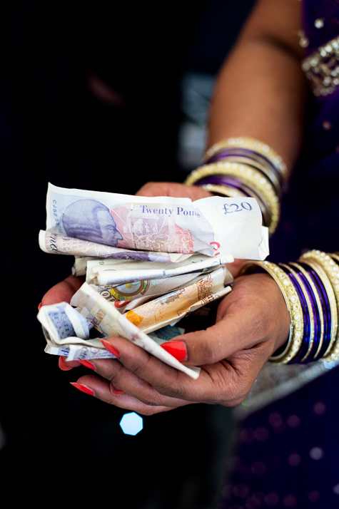 Detail shot of bride's hands holding banknotes, gifts of money