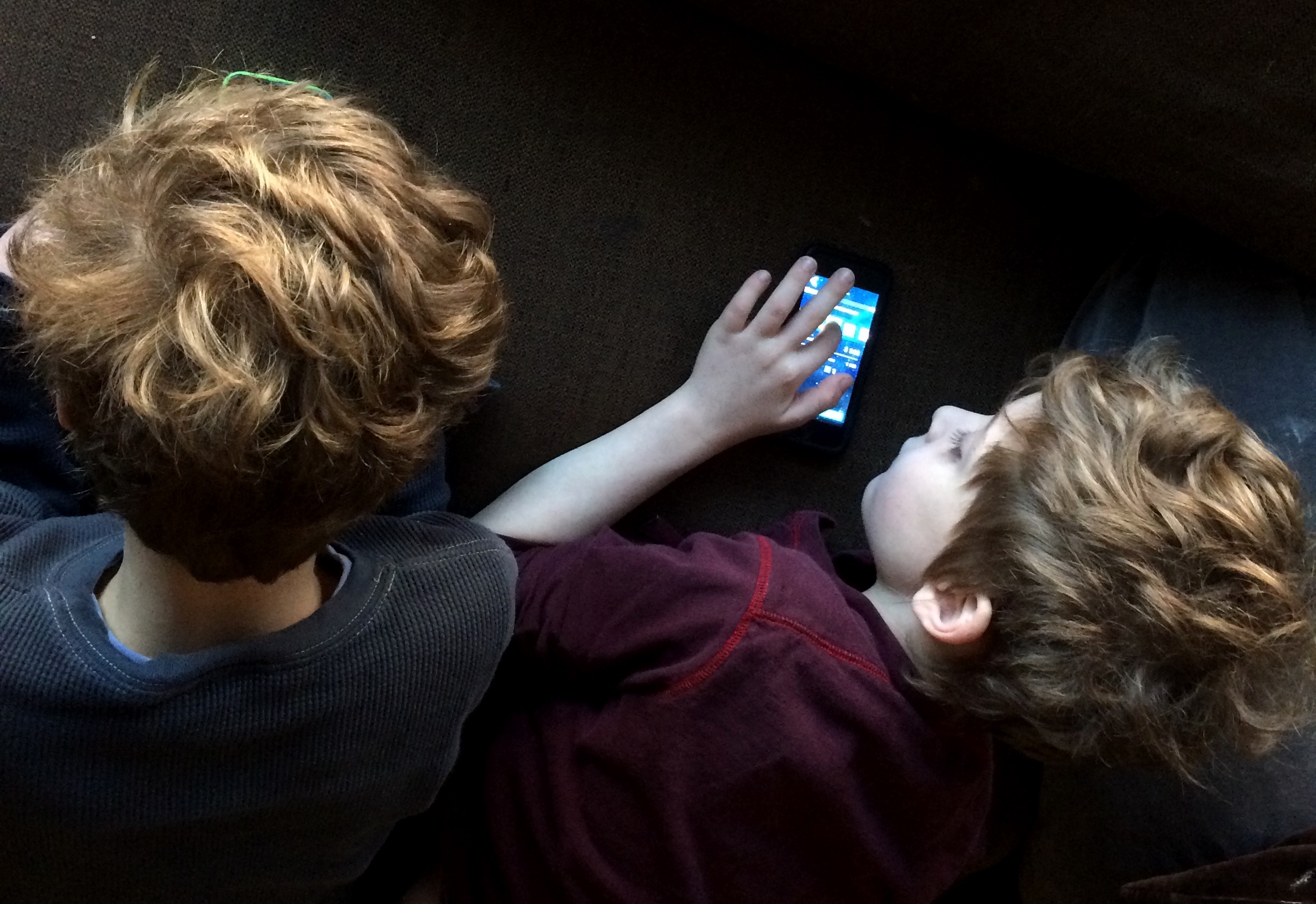 M and C, twin brothers, playing electronic devices next to each other