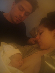 The beautiful new family rest in bed after a fast & furious labor & birth!