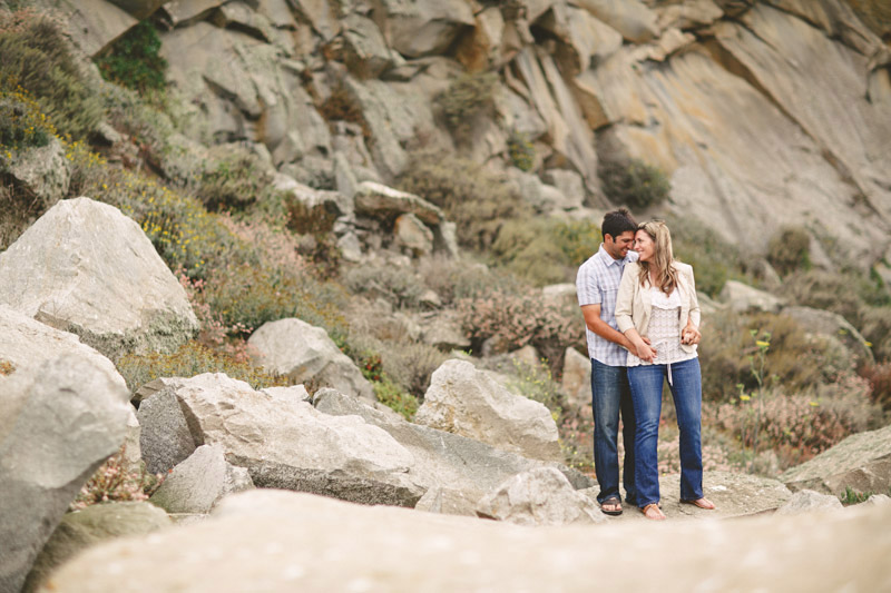 Morro Bay, couple cuddling in front of rocks