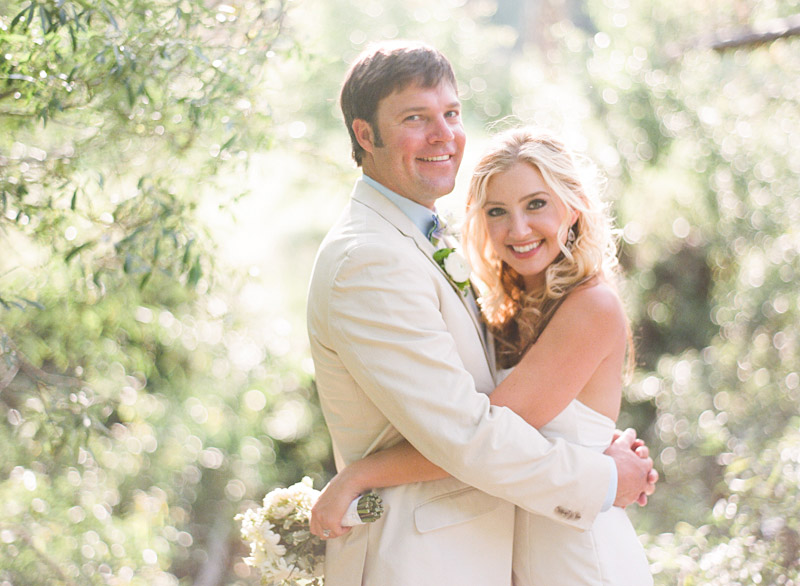 Central Coast Avila Beach Golf Course wedding pictures of bride and groom hugging in front of trees